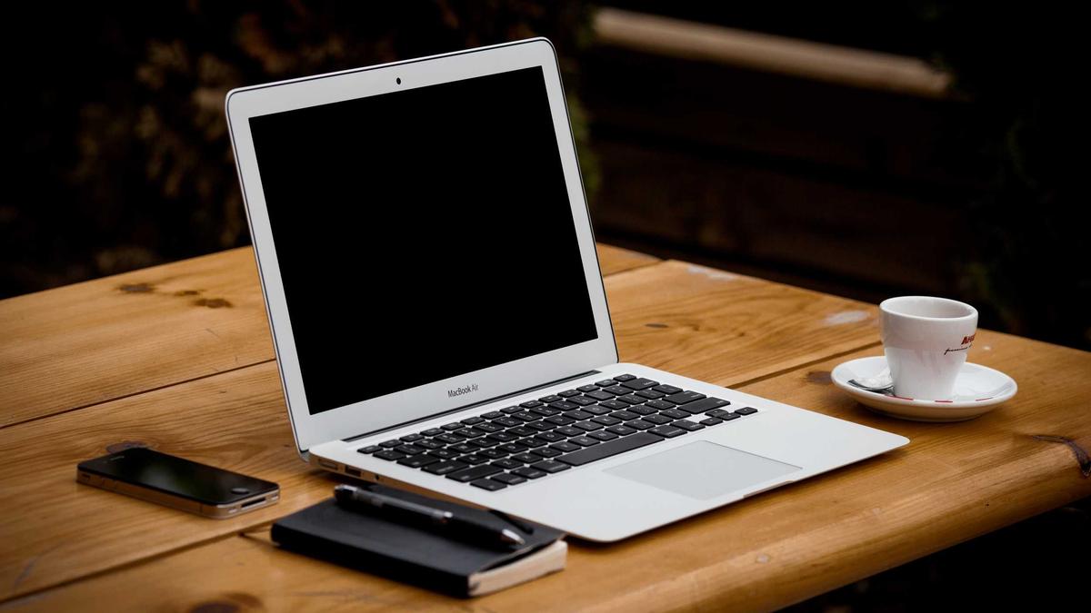 Laptop and coffee on a wooden desk