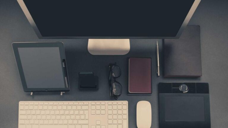 Tablet, phone and keyboard on a dark desk